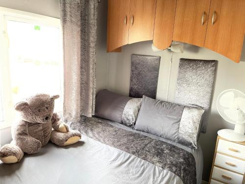 a teddy bear sitting on a bed in a bedroom at Turnberry Holiday Park fantastic Seaview in Girvan