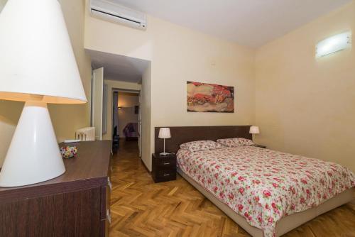 a bedroom with a bed and a table with a lamp at Residence il Duomo in Lucca