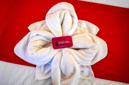 a white towel with a red tag on top of it at Hotel Rosa del Alba in Chetumal