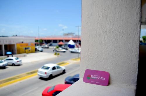 a purple sign on a wall with a view of a highway at Hotel Rosa del Alba, Malecón Chetumal in Chetumal