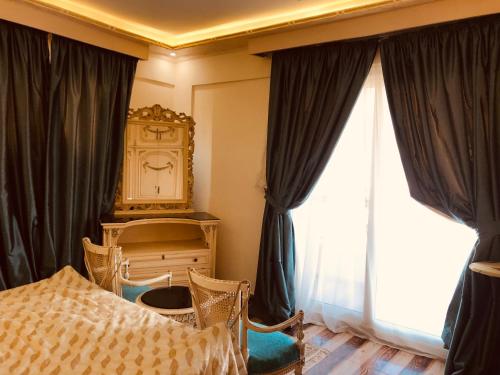a bedroom with a bed and a dresser and windows at Lovely Villa 5- bedroom with Overflow Pool with Nice Garden at Green Oasis Resort in Alexandria