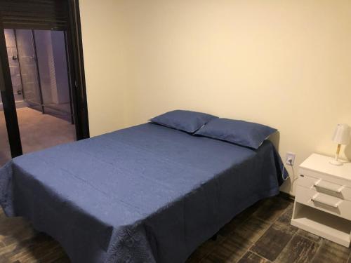 a bedroom with a bed with blue sheets and a mirror at Apartamento céntrico 3 Edificio picazzo en Mercedes Uruguay in Mercedes