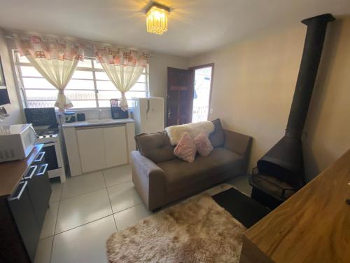 a living room with a couch and a stove at Apartamento aconchegante próximo Capivari in Campos do Jordão