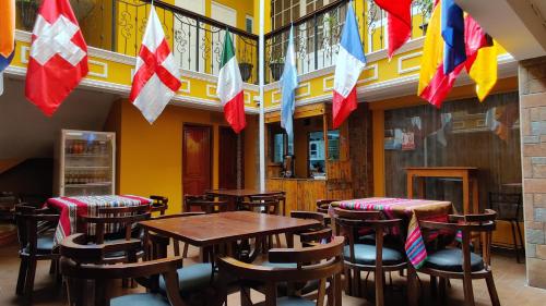 un restaurante con mesas de madera, sillas y banderas en Wake Up Hostel en La Paz