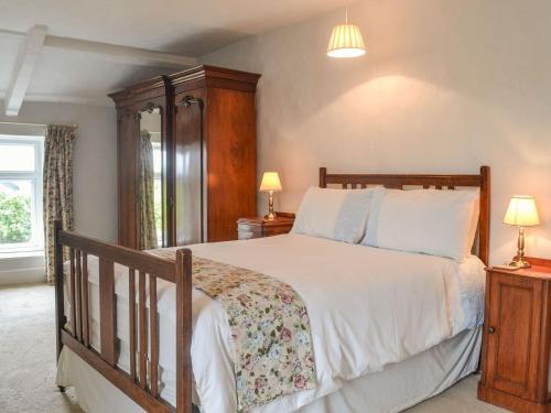 sypialnia z dużym łóżkiem z drewnianym zagłówkiem w obiekcie East Monkton Farm Cottage w mieście Wick