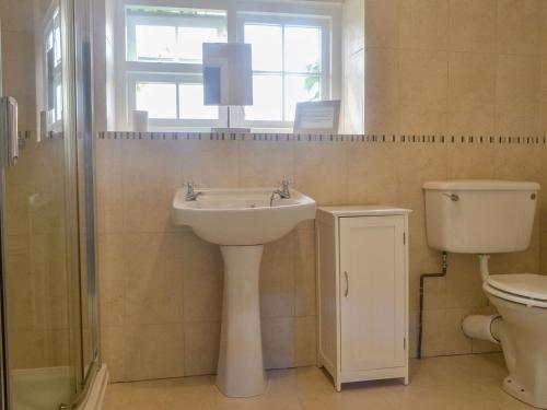 łazienka z umywalką, toaletą i oknem w obiekcie East Monkton Farm Cottage w mieście Wick