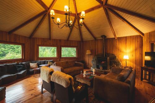 uma sala de estar com sofás e uma lareira em Peuma Lodge Patagonia em Futaleufú