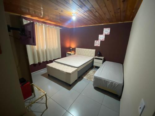 een kleine slaapkamer met een bed en een bank bij Apartamento aconchegante próximo Capivari in Campos do Jordão