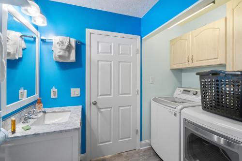 a bathroom with blue walls and a washer and dryer at Willapye Beach House by the Sea in Navarre