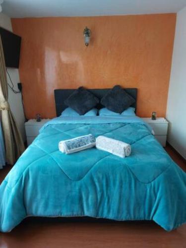 Una cama azul con dos toallas encima. en Hermosa Habitación cerca al aeropuerto en Bogotá