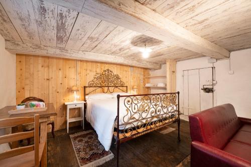 1 dormitorio con cama y techo de madera en B&B Casa Quaroni en Anzino