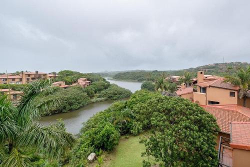 a river in a city with houses and trees at San Lameer Style by Top Destinations Rentals in Southbroom