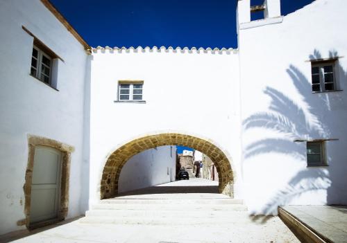 an alley in a white building with an archway at B&B Sa Cruxitta in Portoscuso