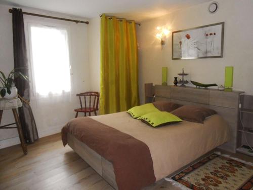 Un dormitorio con una cama grande y una ventana en Les Locations du Puits, en Rochefort-en-Terre