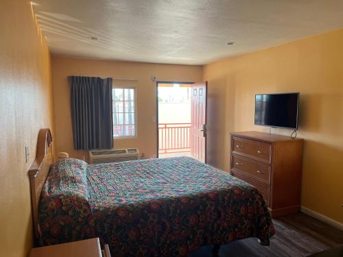een slaapkamer met een bed en een flatscreen-tv bij Palm Tree Inn in North Hills