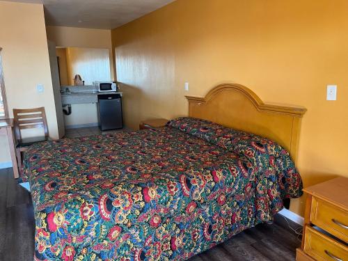 a bedroom with a bed with a colorful bedspread at Palm Tree Inn in North Hills