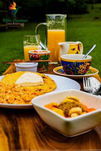Una mesa con un plato de comida y un tazón de comida. en Villa Cristina - Casa Boutique, en Pereira