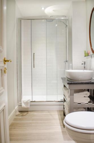 a bathroom with a shower and a toilet and a sink at Tulse Hill Hotel in London