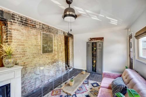 a living room with a couch and a brick wall at Chic Troy Home Near Downtown, 9 Mi to Albany! in Troy