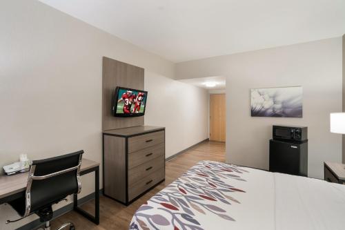 a hotel room with a bed and a desk and a computer at Red Roof Inn & Suites Carrollton, GA - West Georgia in Carrollton