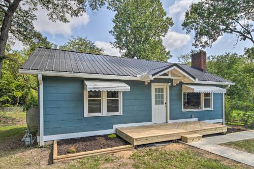 a blue tiny house with a porch at Cozy Arden Cottage, 2 Mi to Lake Julian Park! in Arden