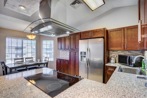 a kitchen with a stainless steel refrigerator and a table at 7 Mi to Dtwn Chandler Pet-Friendly Condo with Pool in Chandler