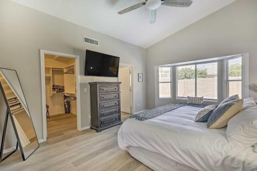 a bedroom with a bed and a flat screen tv at Chic Phoenix Home with Yard and Private Heated Pool! in Phoenix