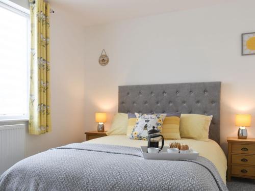 a bedroom with a large bed with a gray headboard at Westways in Bridlington