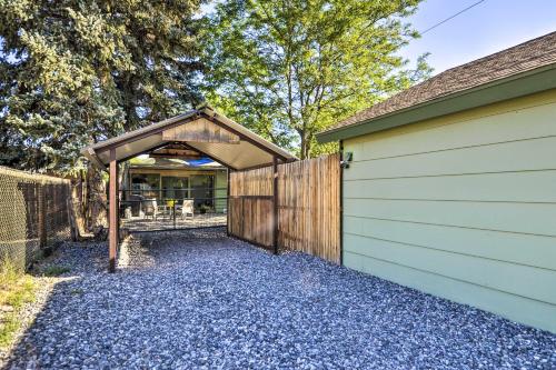 a garage with a wooden door and a fence at Beautiful Cody Abode with Grill - Walk to Downtown! in Cody
