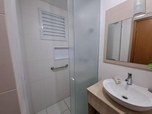 y baño con lavabo y ducha con espejo. en Nautilus Apartment Vista Mar, en Penha
