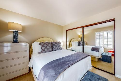 a bedroom with two beds and a mirror at Spring into Oasis Permit# 5140 in Palm Springs