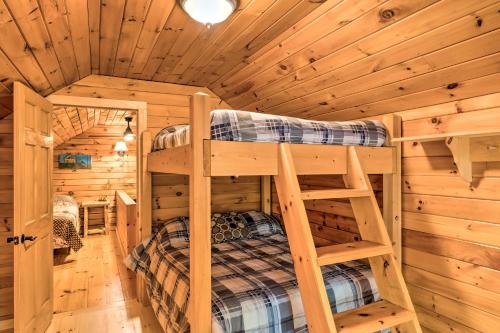 a bedroom with two bunk beds in a log cabin at Magnificent Victory Cabin with Private Hot Tub! 