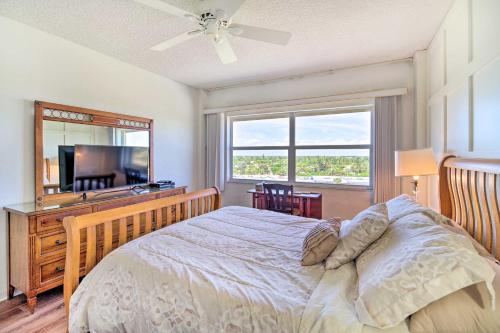 a bedroom with a bed and a large window at Steps to Sand Satellite Beach Condo with Views! in Satellite Beach
