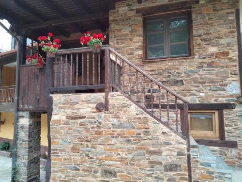 a stone house with a staircase and flowers on it at VUT El Pajariel Ponferrada in Ponferrada