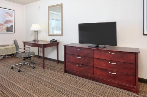 a room with a dresser with a television and a desk at Homewood Suites by Hilton Santa Maria in Santa Maria