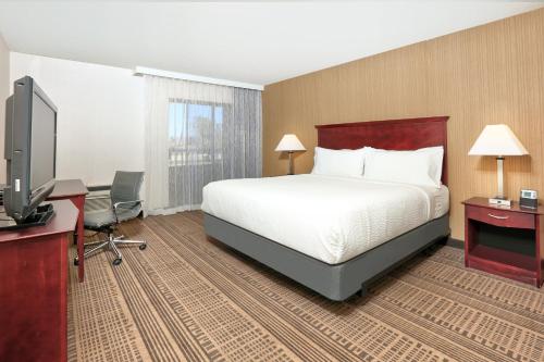 a hotel room with a bed and a flat screen tv at Homewood Suites by Hilton Santa Maria in Santa Maria