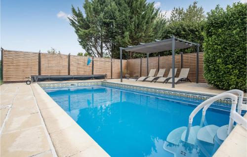 a swimming pool with two chairs and an umbrella at Wisteria in Nanclars
