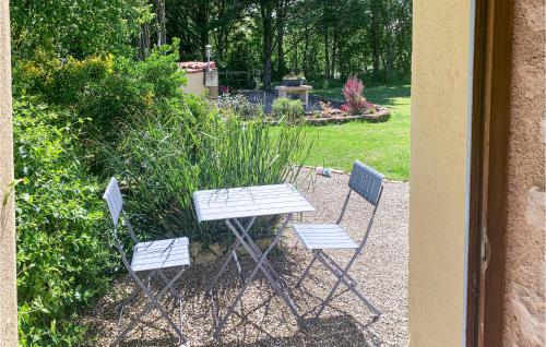 a picnic table and two chairs in a garden at Wisteria in Nanclars