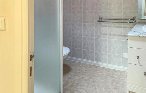 een badkamer met een toilet en een glazen douchedeur bij Wisteria in Nanclars