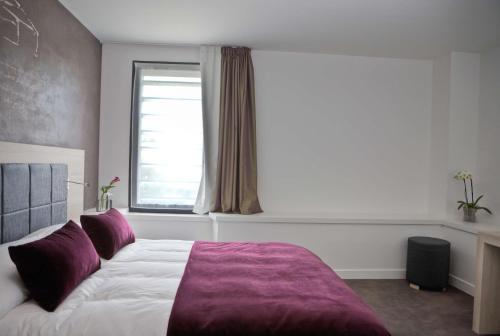 a bedroom with a large bed and a window at Best Western Plus Villa Saint Antoine Hotel & Spa in Clisson