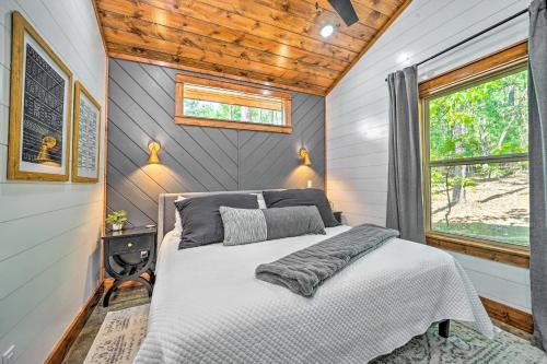 1 dormitorio en una casa pequeña con 1 cama en Chic Broken Bow Cabin with Hot Tub and Gas Grill!, en Broken Bow