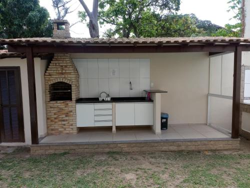 an outdoor kitchen with a brick oven on a patio at Pousada Cabufa in Cabo Frio