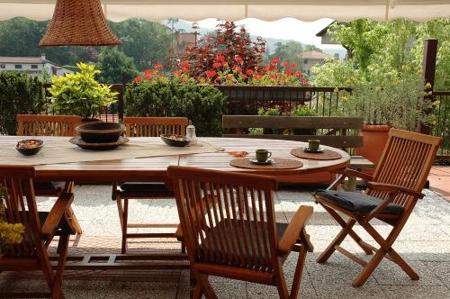 un tavolo e sedie in legno su un patio di villa ginestra a Negrar