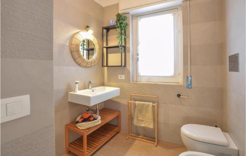 een badkamer met een wastafel, een toilet en een raam bij Beautiful Apartment In Pozzallo With Kitchen in Pozzallo