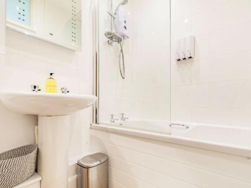 a white bathroom with a sink and a shower at Claro Cottage - Uk37450 in Pateley Bridge