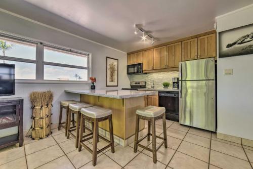 a kitchen with a green refrigerator and bar stools at Beautiful Kihei Condo - Walk to the Beach! in Kihei