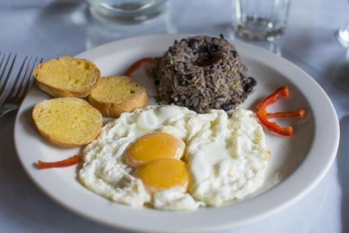 a plate of food with eggs and peppers on a table at Bosque de Paz Reserva Biologica in Toro Amarillo
