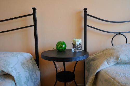 a table with a bowl on it next to two beds at B&B Gate 52 in Pisa