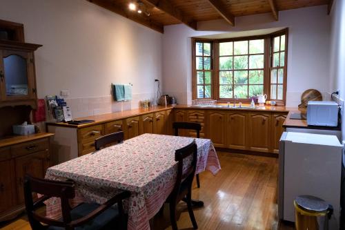 a kitchen with a table with a table cloth on it at Gellibrand River Gallery Accommodation in Gellibrand