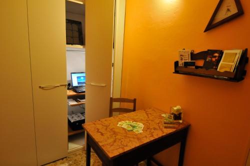 a room with a table and a desk with a computer at B&B Gate 52 in Pisa
